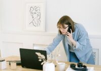 Woman multitasking with laptop and phone in modern home office setting., tags: guest blogging di - pexel