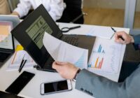 Professionals analyzing charts and graphs on laptops during a business meeting., tags: dei tassi - pexel